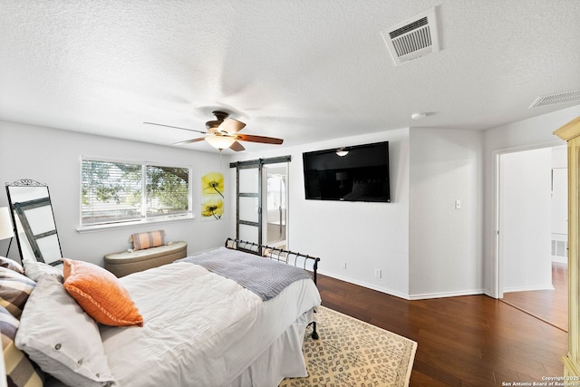 bedroom with visible vents, wood finished floors, and a ceiling fan