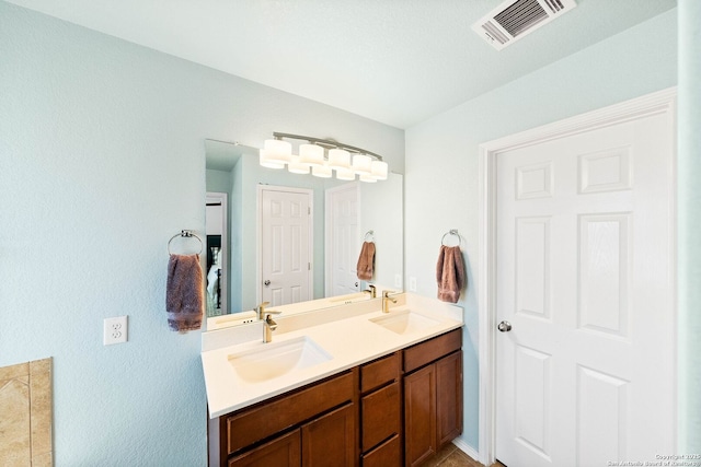 bathroom featuring double vanity, visible vents, and a sink