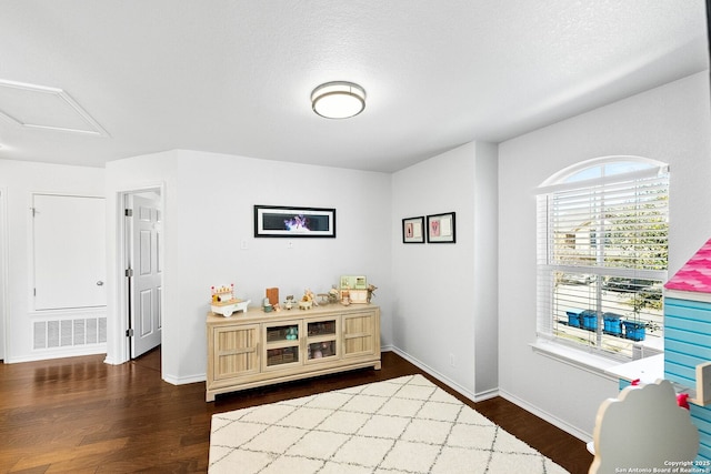 interior space featuring visible vents, baseboards, and dark wood finished floors