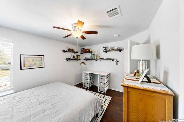 bedroom featuring visible vents, dark wood-type flooring, and ceiling fan