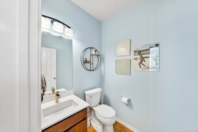 half bathroom with toilet, vanity, and baseboards