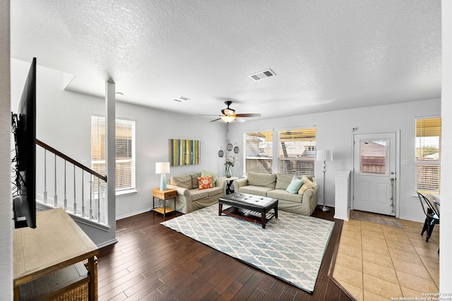 living area with visible vents, wood finished floors, a healthy amount of sunlight, and ceiling fan