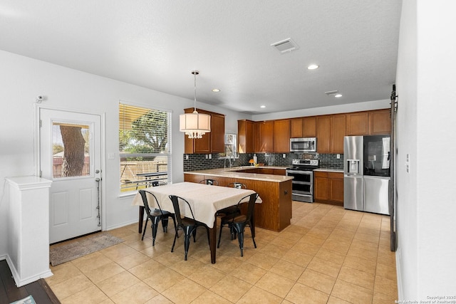 kitchen with decorative backsplash, light countertops, visible vents, and stainless steel appliances