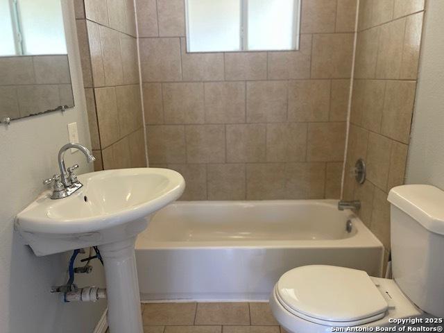 bathroom with tile patterned floors, toilet, and shower / washtub combination