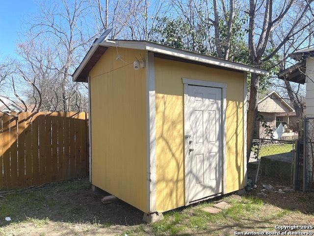 view of shed featuring fence