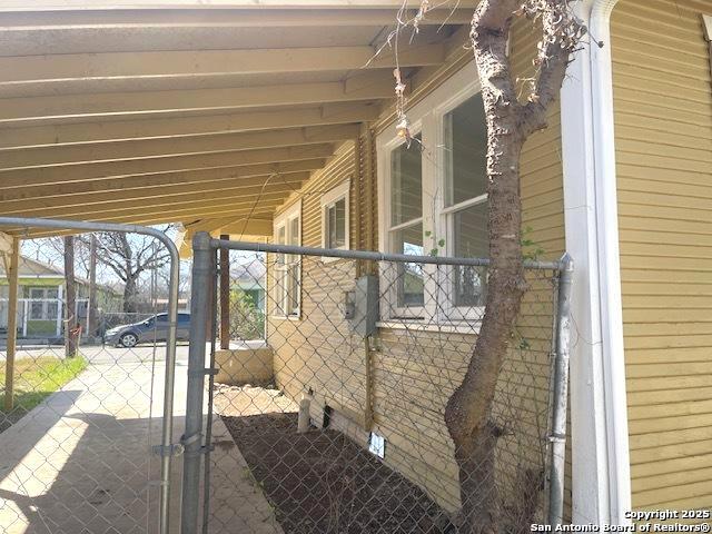 view of side of property featuring crawl space and a gate