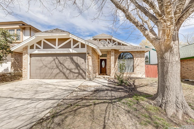 view of front of house featuring brick siding, driveway, a garage, and fence