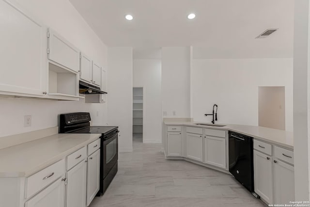 kitchen featuring visible vents, under cabinet range hood, a peninsula, black appliances, and a sink