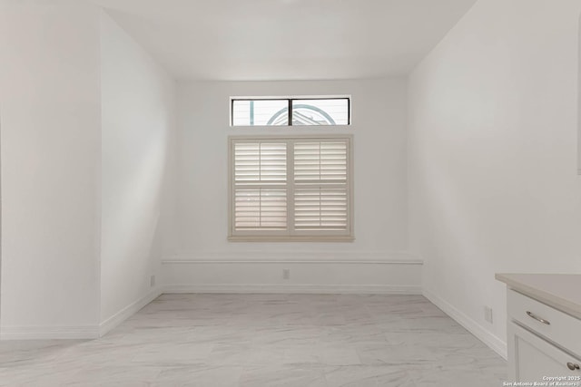 spare room with baseboards and marble finish floor