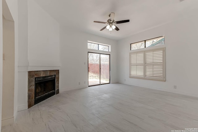 unfurnished living room with a fireplace, baseboards, and ceiling fan