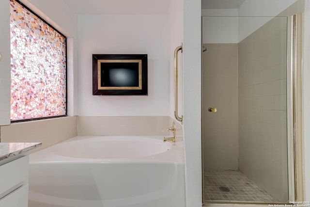 full bath featuring a stall shower, vanity, and a garden tub