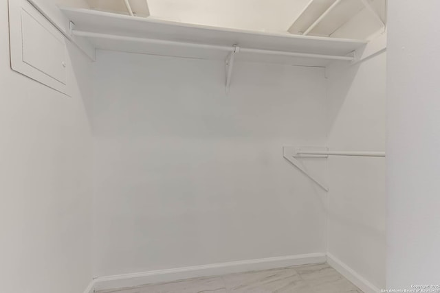 walk in closet with marble finish floor