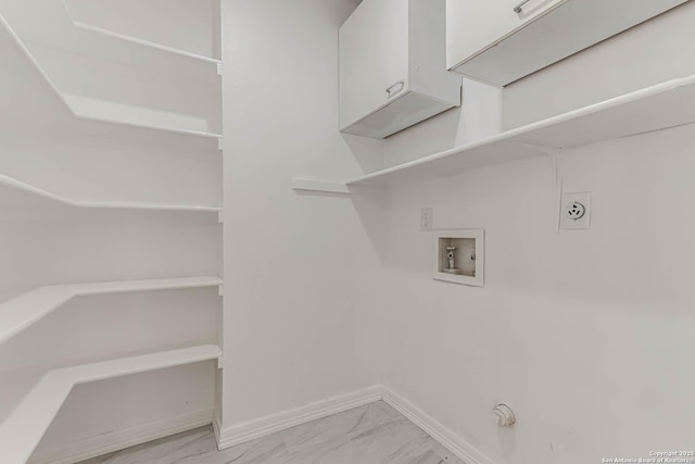 laundry room featuring cabinet space, electric dryer hookup, marble finish floor, and baseboards