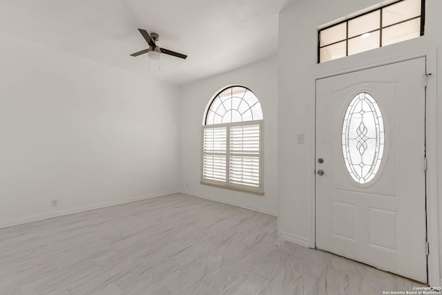 entryway featuring a ceiling fan and baseboards