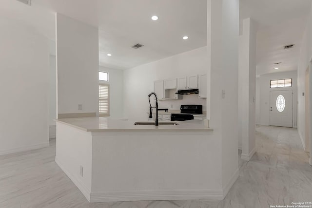 kitchen featuring black electric range, a healthy amount of sunlight, visible vents, and under cabinet range hood