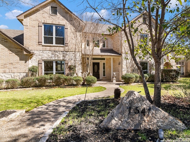 view of front of house with stone siding and a front lawn