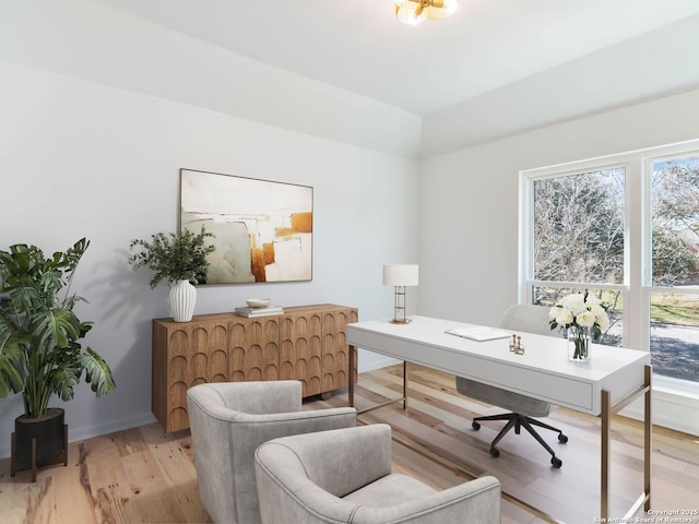 home office with light wood-type flooring, plenty of natural light, and baseboards