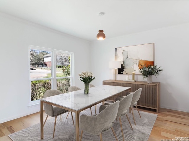 dining room featuring baseboards and light wood finished floors