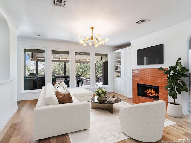 living room featuring light wood finished floors, visible vents, a brick fireplace, and ornamental molding