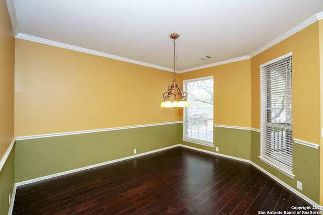 spare room featuring crown molding, wood finished floors, visible vents, and baseboards