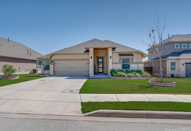 prairie-style home with stucco siding, a front lawn, stone siding, concrete driveway, and an attached garage