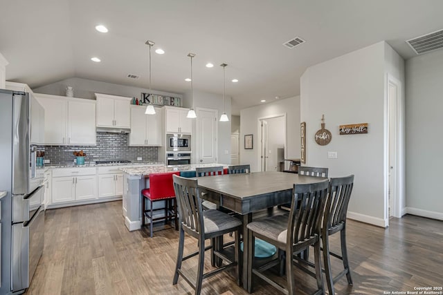 dining space with visible vents, baseboards, and dark wood-style flooring