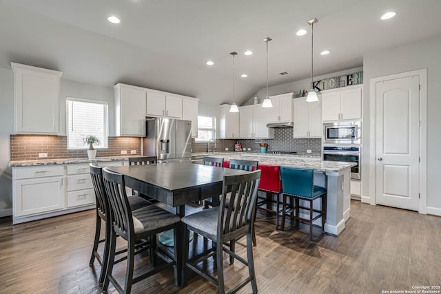 kitchen with white cabinets, a center island, dark wood-style floors, and stainless steel appliances