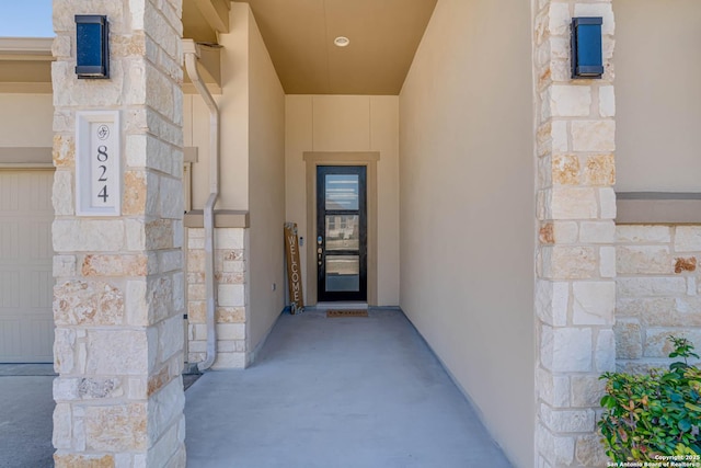 view of exterior entry featuring stucco siding and stone siding