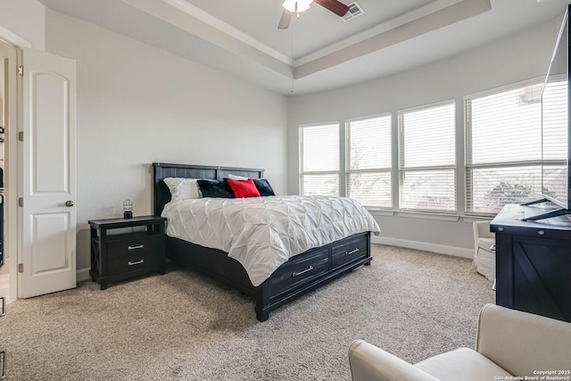 bedroom with visible vents, crown molding, baseboards, light colored carpet, and a tray ceiling