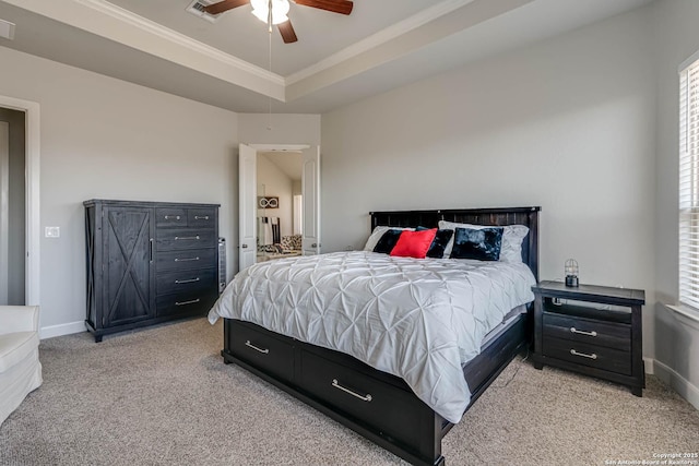 bedroom with a tray ceiling, baseboards, light colored carpet, and visible vents