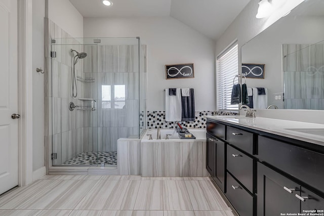 bathroom featuring a garden tub, a stall shower, vanity, and lofted ceiling