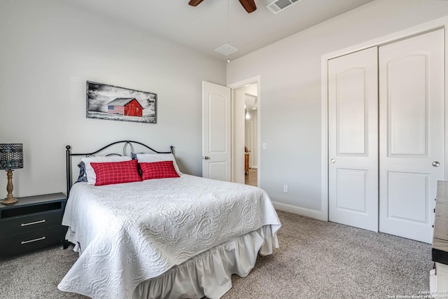 carpeted bedroom with a closet, visible vents, baseboards, and ceiling fan