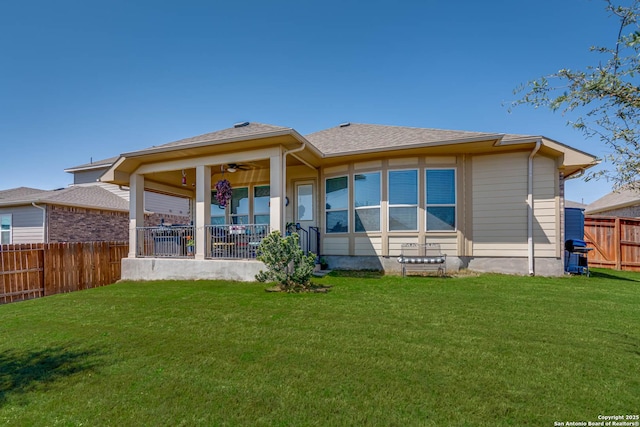 back of house with a fenced backyard, a ceiling fan, a yard, and a shingled roof