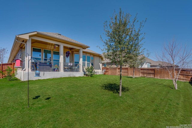 view of yard with fence private yard and ceiling fan