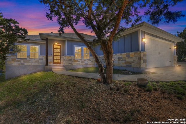 view of front of property with a garage, stone siding, board and batten siding, and concrete driveway