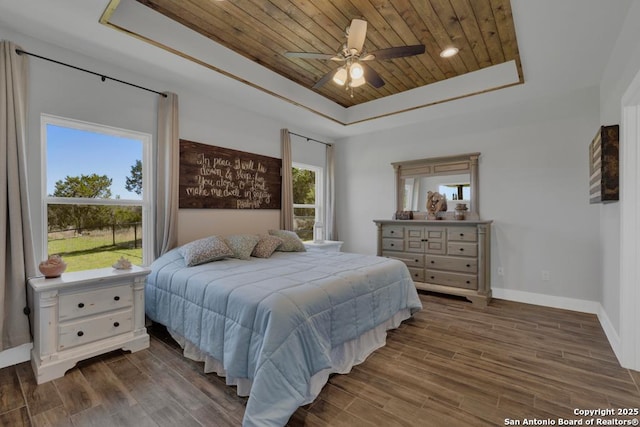 bedroom featuring baseboards, wood ceiling, a tray ceiling, and wood finished floors