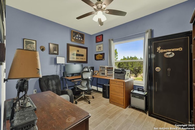 home office with light wood-type flooring and ceiling fan