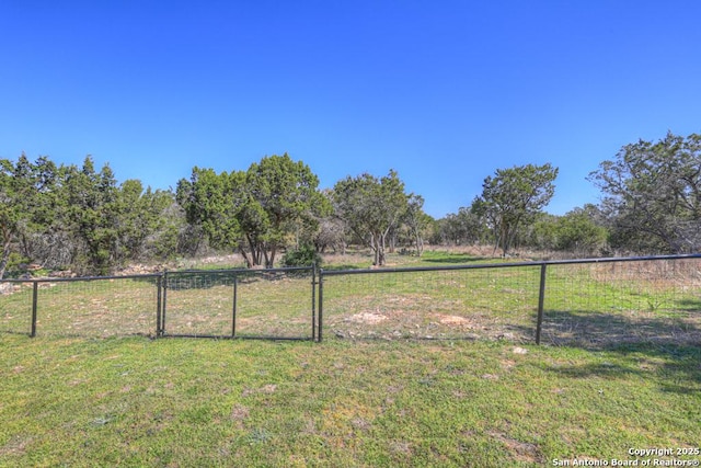 view of yard with a rural view and fence