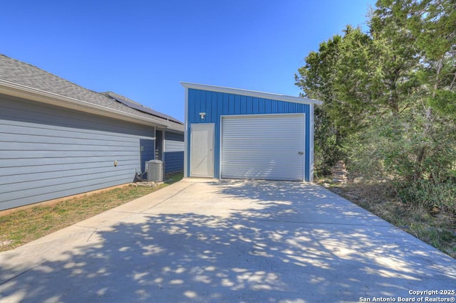 garage featuring central AC unit and driveway