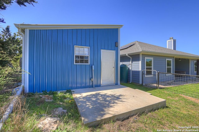 exterior space featuring a yard, a patio area, fence, and a chimney