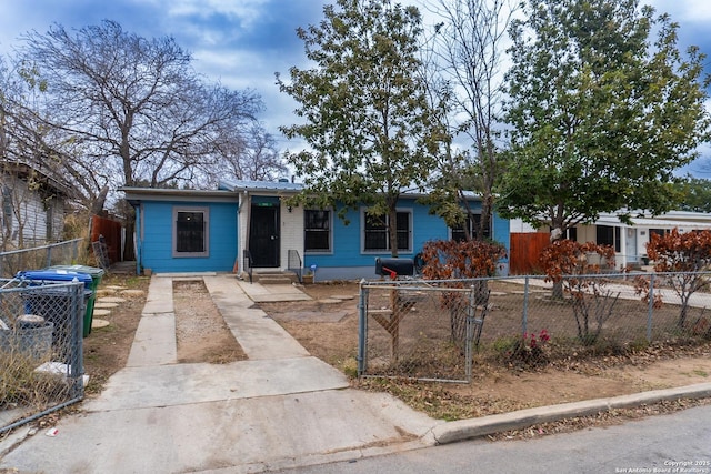 view of front of house with concrete driveway and a fenced front yard