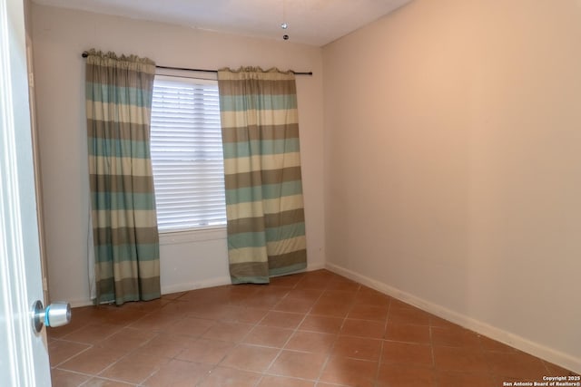 unfurnished room featuring tile patterned floors and baseboards