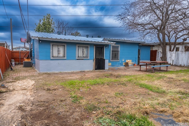 view of front of house with metal roof and a fenced backyard