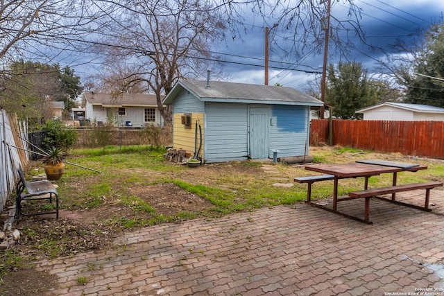 rear view of house featuring a fenced backyard, a patio, a storage shed, and an outdoor structure