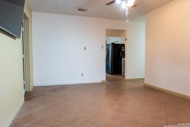 spare room featuring light tile patterned floors, visible vents, baseboards, and ceiling fan