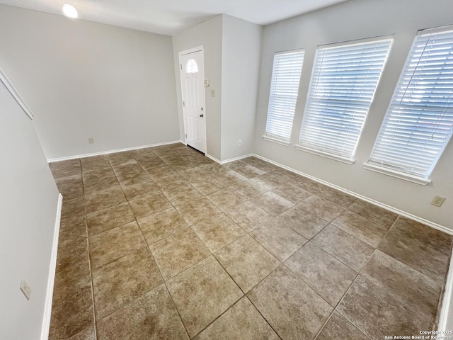 unfurnished room featuring tile patterned floors and baseboards