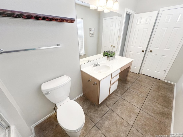 bathroom featuring tile patterned flooring, toilet, vanity, and baseboards