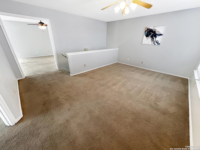 carpeted spare room with baseboards and a ceiling fan