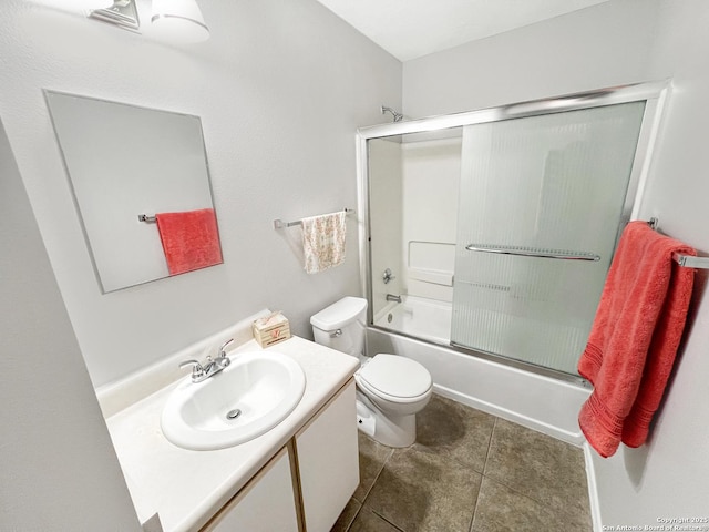 full bath featuring combined bath / shower with glass door, toilet, vanity, and tile patterned floors