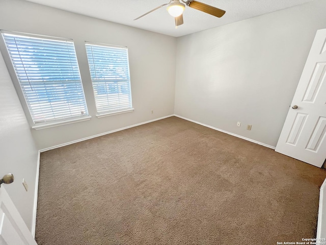 unfurnished bedroom featuring dark carpet, baseboards, and ceiling fan